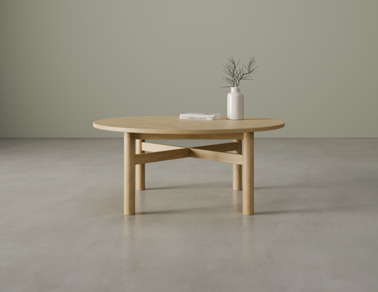 Nordica round wooden coffee table in natural oak finish with a white vase on a polished concrete floor.