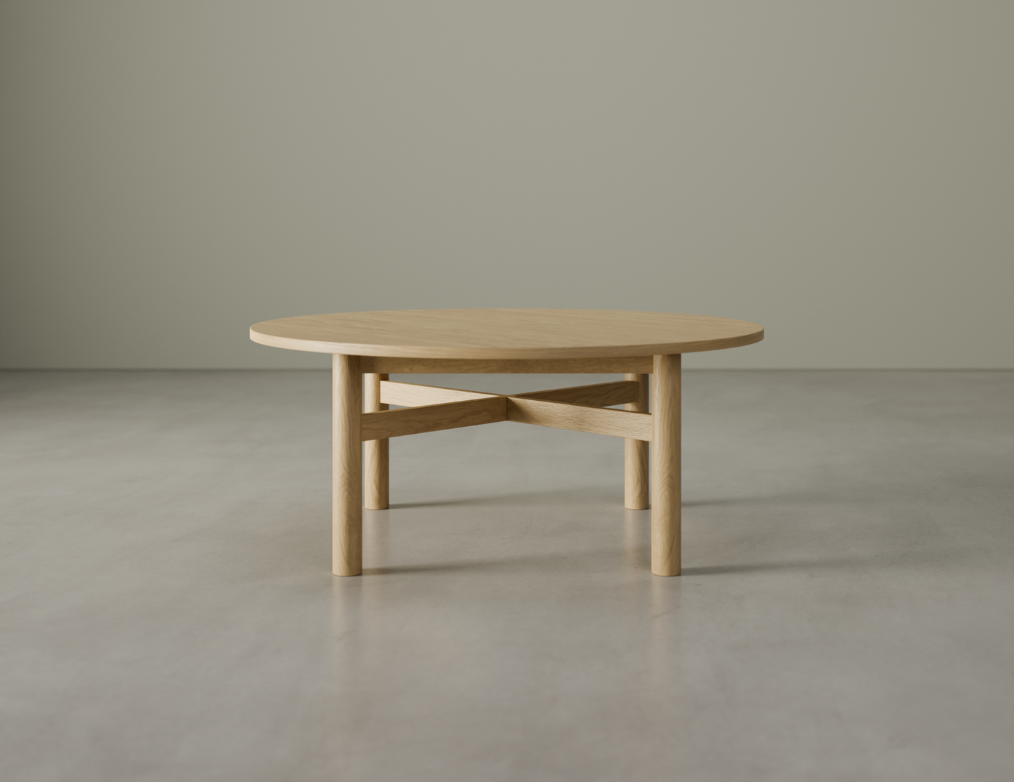 Nordica round wooden coffee table in natural oak finish on a polished concrete floor.