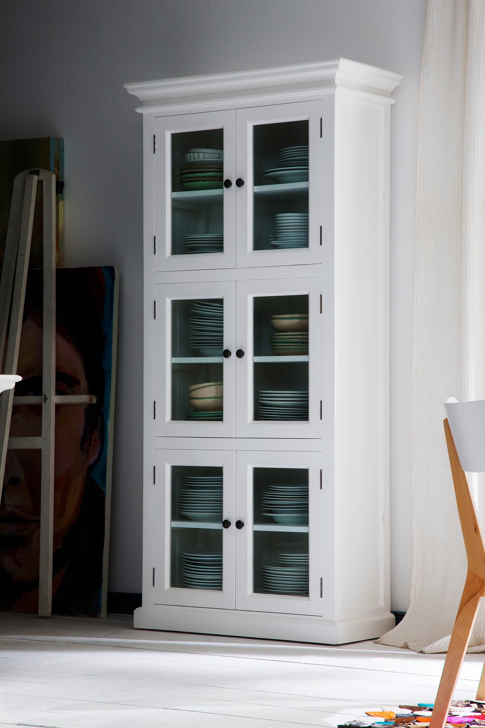 Traditional white timber cabinet with 6 glass doors in a room with white carpet and other various furniture.