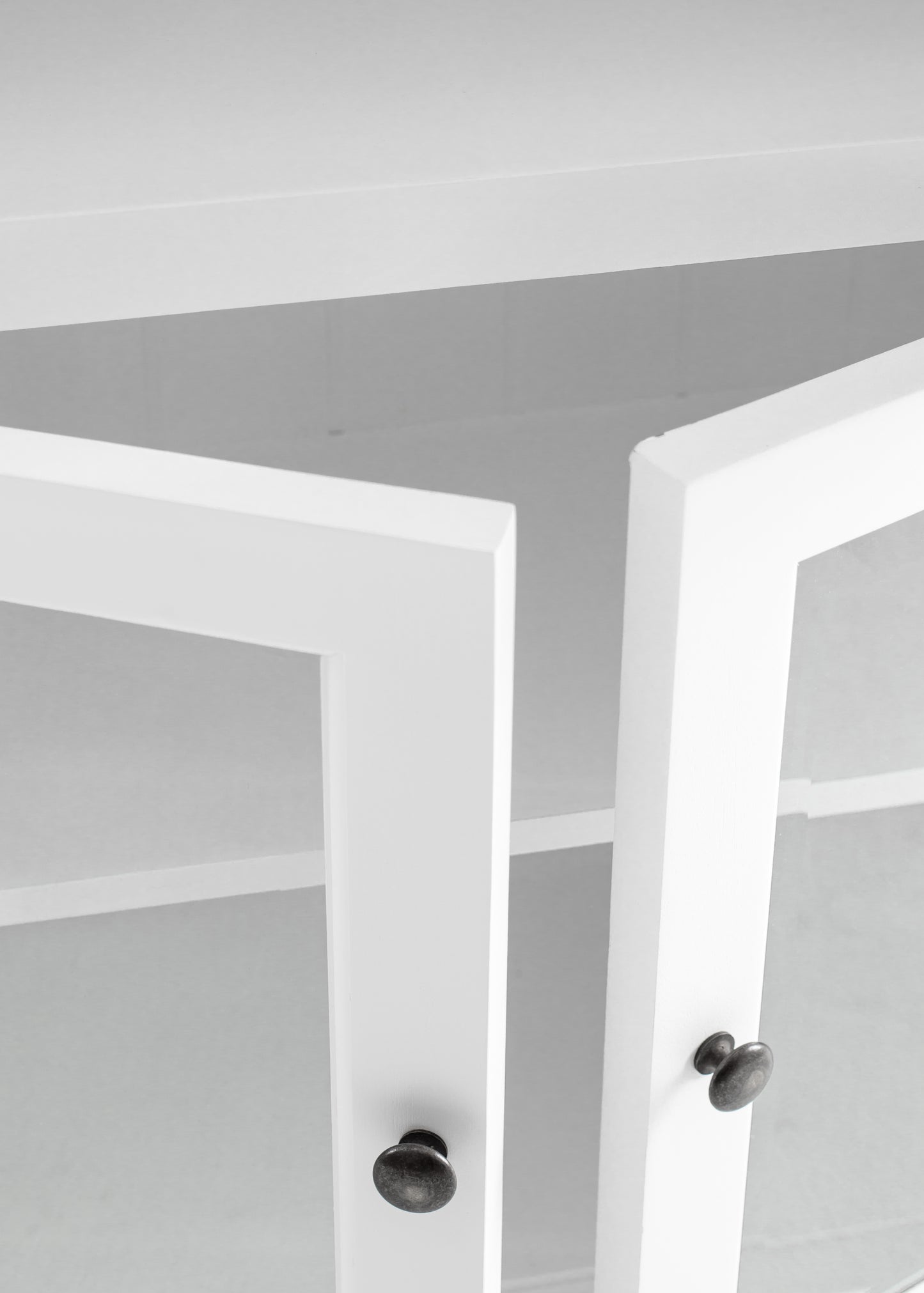 Close-up view of cabinet doors slightly open on traditional 3 level white timber pantry.