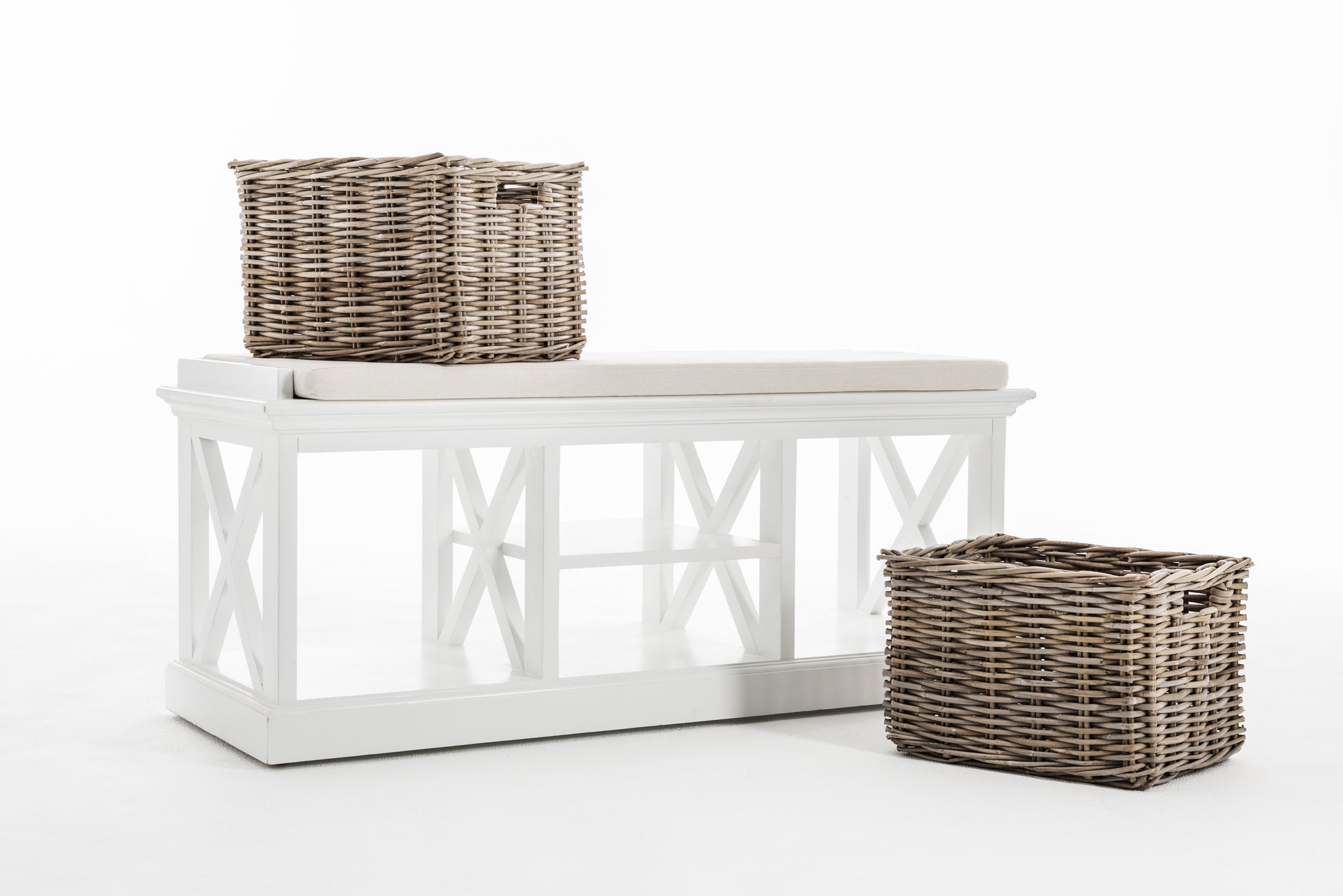 White timber bench with cushion and 2 baskets, 1 on the ground and 1 on the bench.
