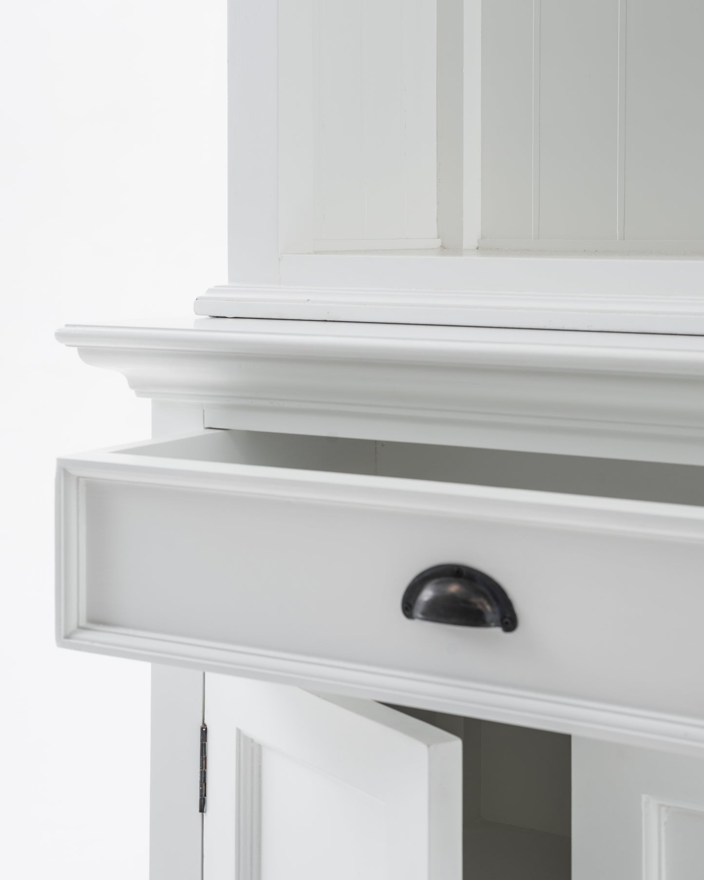 Cloe-up view of an open drawer and door from a white wooden buffet hutch unit with antique brass hardware.