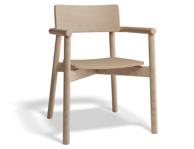 Three-quarter front view of Andi Armchair Natural solid oak dining chair, showcasing curved armrests, contoured seat, sturdy frame, and light wood grain finish isolated on a white background.