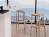 Andi Backless Bar Stool - Natural - 66 cm Seat Height stools in a bright modern kitchen with floor-to-ceiling windows, showcasing sleek design and everyday usability.