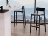 Modern kitchen setting with Andi Bar Stool - Black - 75 cm Seat Height stools near a large window, showcasing sleek black finish and minimalist aesthetic.