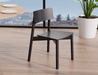 Side perspective of Andi Dining Chair Black near a dining table and indoor plant, highlighting clean lines, solid wood construction, and contemporary Scandinavian style.