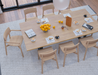 Breakfast dining arrangement with wooden table, coffee, pastries, and fruit centerpiece, surrounded by Andi Dining Chair Natural.