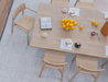 Top view breakfast dining setup with large wooden table, coffee cups, pastries, and oranges centerpiece, surrounded by Andi Dining Chair Natural.