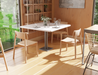 Airy restaurant interior with square cafe tables and decorative shelving, featuring Andi Dining Chair Natural seating.