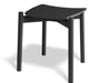 Three quarter front view of Andi Low Stool Black 45 cm seat height showcasing sculpted seat angled legs and smooth black wood finish