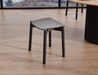 Front perspective of Andi Low Stool Black 45 cm seat height placed in modern interior with wooden flooring highlighting compact size and contemporary style