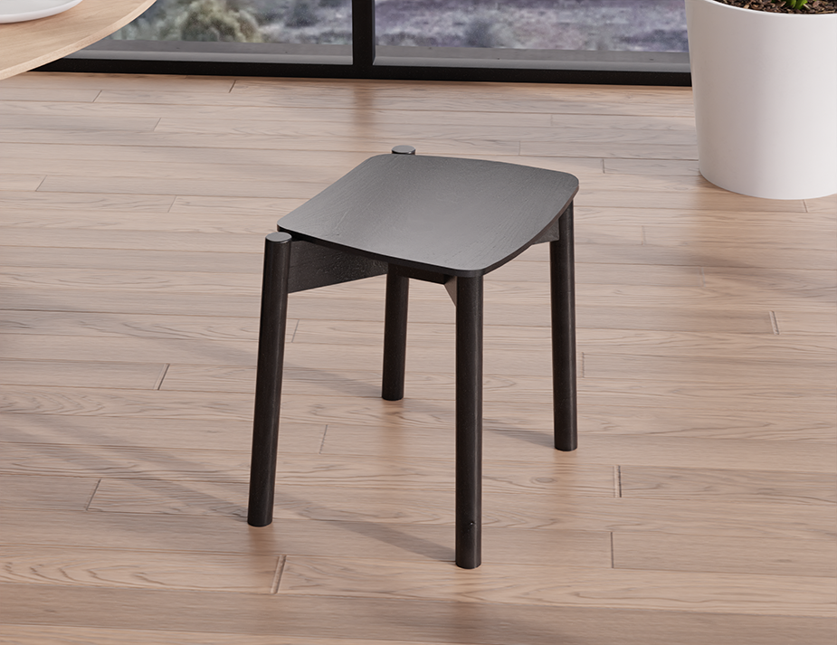Rear angled view of Andi Low Stool Black 45 cm seat height showing curved seat edges and sturdy cylindrical legs in modern living space
