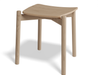 Three-quarter front view of Andi Low Stool Natural 45 cm Seat Height showcasing sculpted seat, angled legs, and smooth natural oak wood grain.