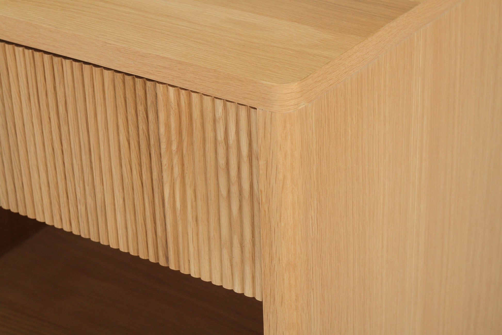 Angled corner view of Harlow Bedside Table – Natural with fluted drawer detail and rounded timber edges