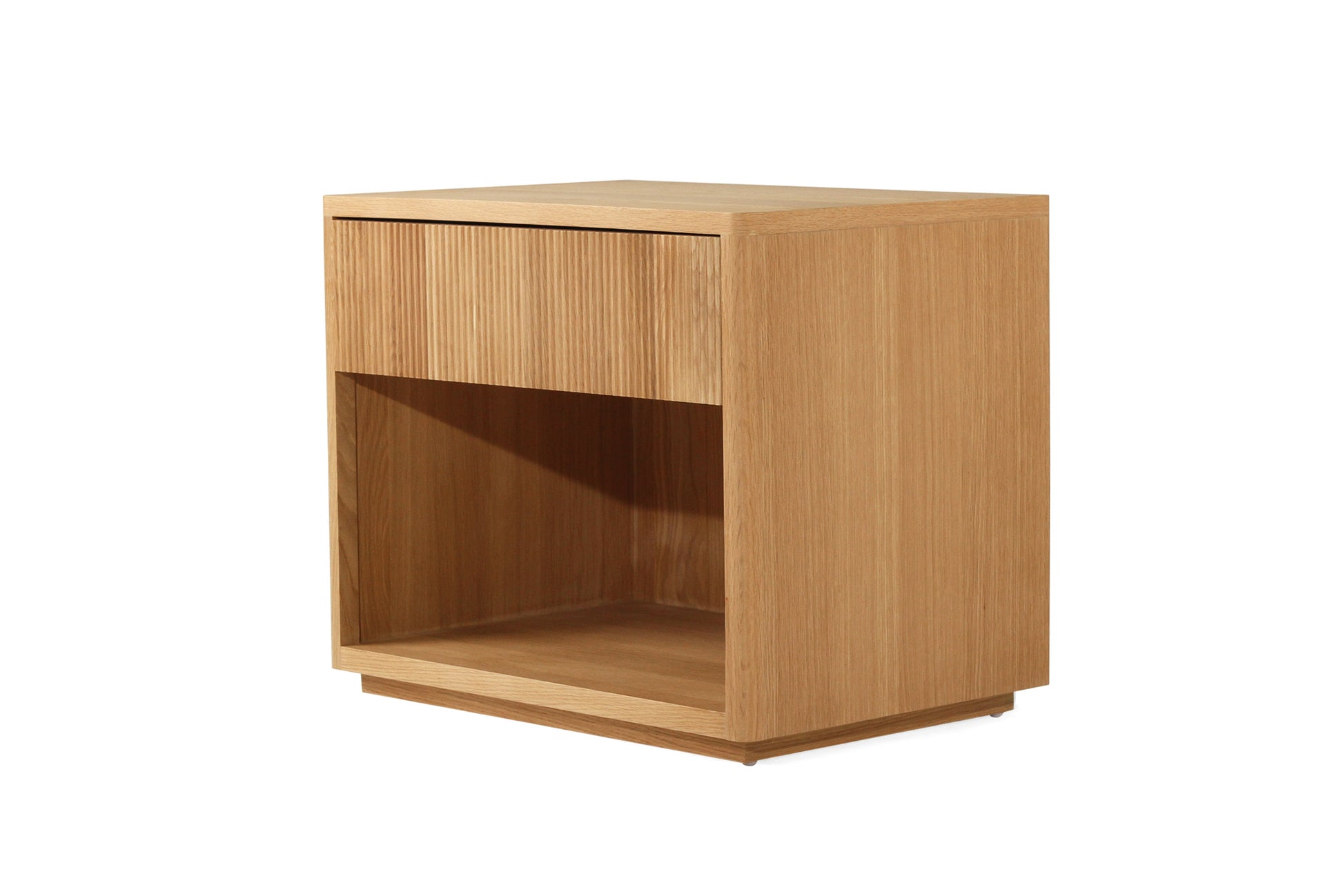 Angled closed drawer view of Harlow Bedside Table – Natural with ribbed timber detail and open base shelf