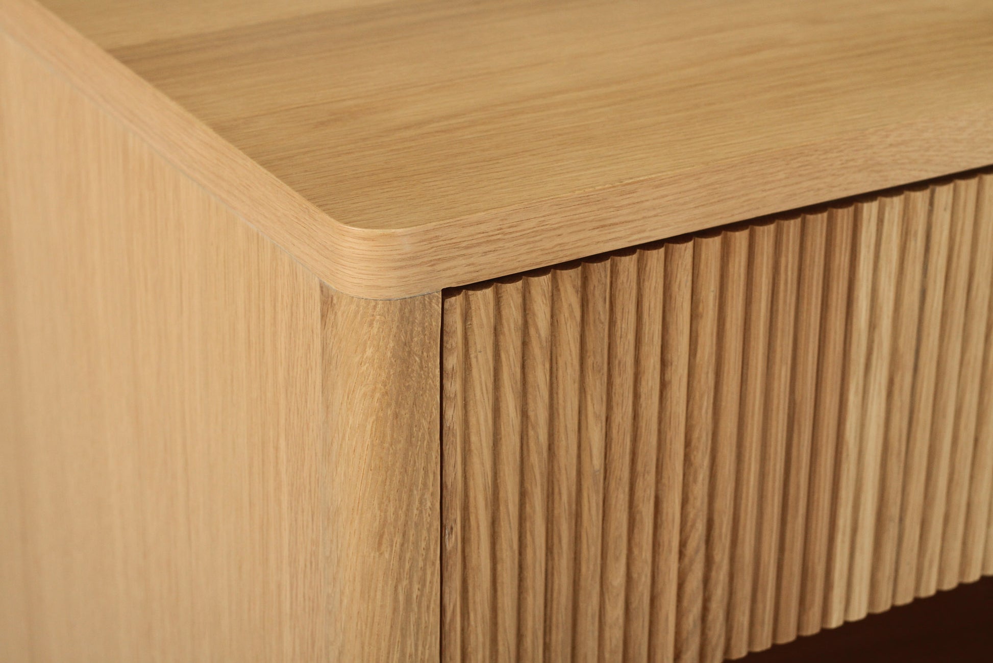 Close-up angled view of Harlow Bedside Table – Natural highlighting ribbed drawer front and smooth oak top