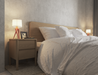 Natural wood bedside table with 2 drawers next to a natural wooden bed.  The table has a lamp and picture frame displayed on it.