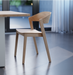 Wooden dining chair in natural ash finish on a polished concrete floor.