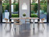 Natural wood dining chairs in a modern dining room with a wooden table with white legs looking outside to a large courtyard.
