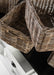 Close-up of natural rattan storage baskets showing the handwoven texture and warm coastal finish.