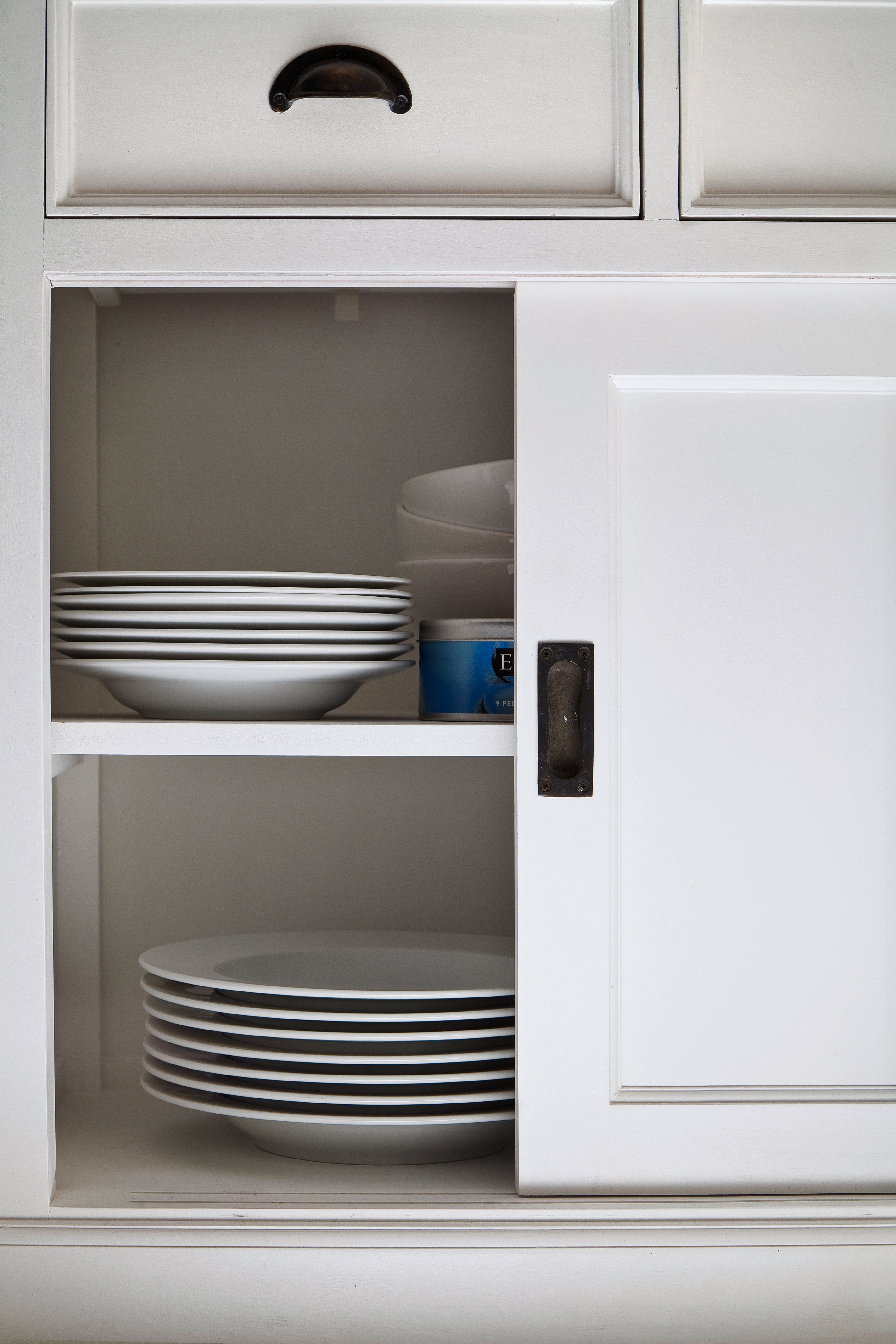 Close-up of the Halifax Contrast Buffet with Sliding Doors, showing stacked plates inside the open cupboard and the recessed sliding door handle.