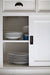 Close-up of the Halifax Contrast Buffet with Sliding Doors, showing stacked plates inside the open cupboard and the recessed sliding door handle.