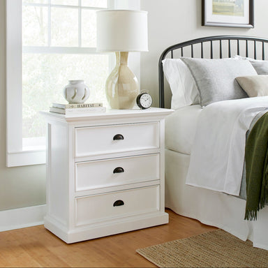 Halifax Grand Bedside Drawer Unit styled beside a bed with a lamp, books, alarm clock and soft neutral bedding.