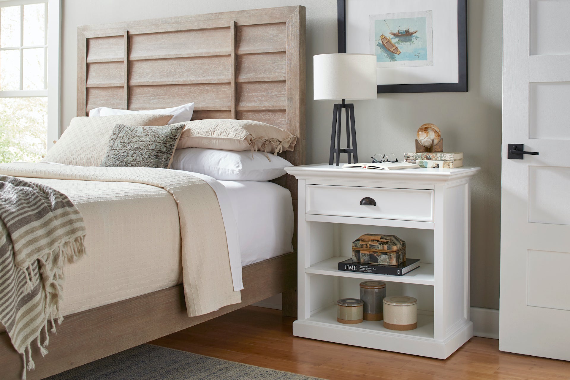 Close-up of the Halifax Grand Bedside Table styled with an open book, glasses, lamp and decorative objects.