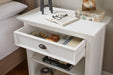 Halifax Grand Bedside Table styled in a bedroom beside a timber bed, with one drawer and open shelving for books and decor.
