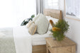 Side angle of Hamilton Cane Super King Bed showing natural rattan headboard, white linen bedding and coastal bedroom styling