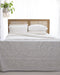 Front view of Hamilton Cane Super King Bed with woven rattan headboard styled with white bedding and patterned throw blanket