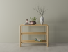 Front view of a 2 tier bookshelf made from American oak displaying books and vases on a polished concrete floor.