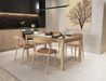 Nordica wooden dining table in natural oak finish in a dining setting with 4 wooden chairs with assorted items on table.