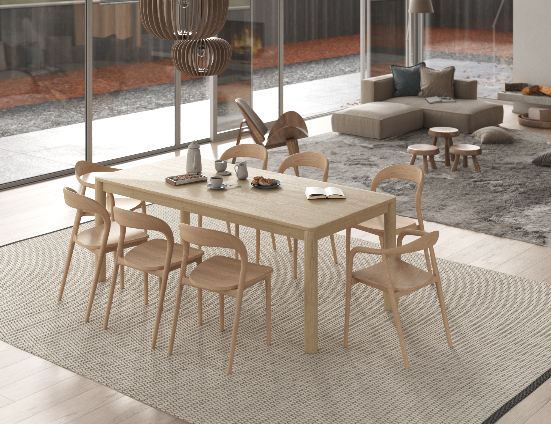 Nordica wooden dining table and chairs in natural oak finish on a natural rug in a light filled open plan room.