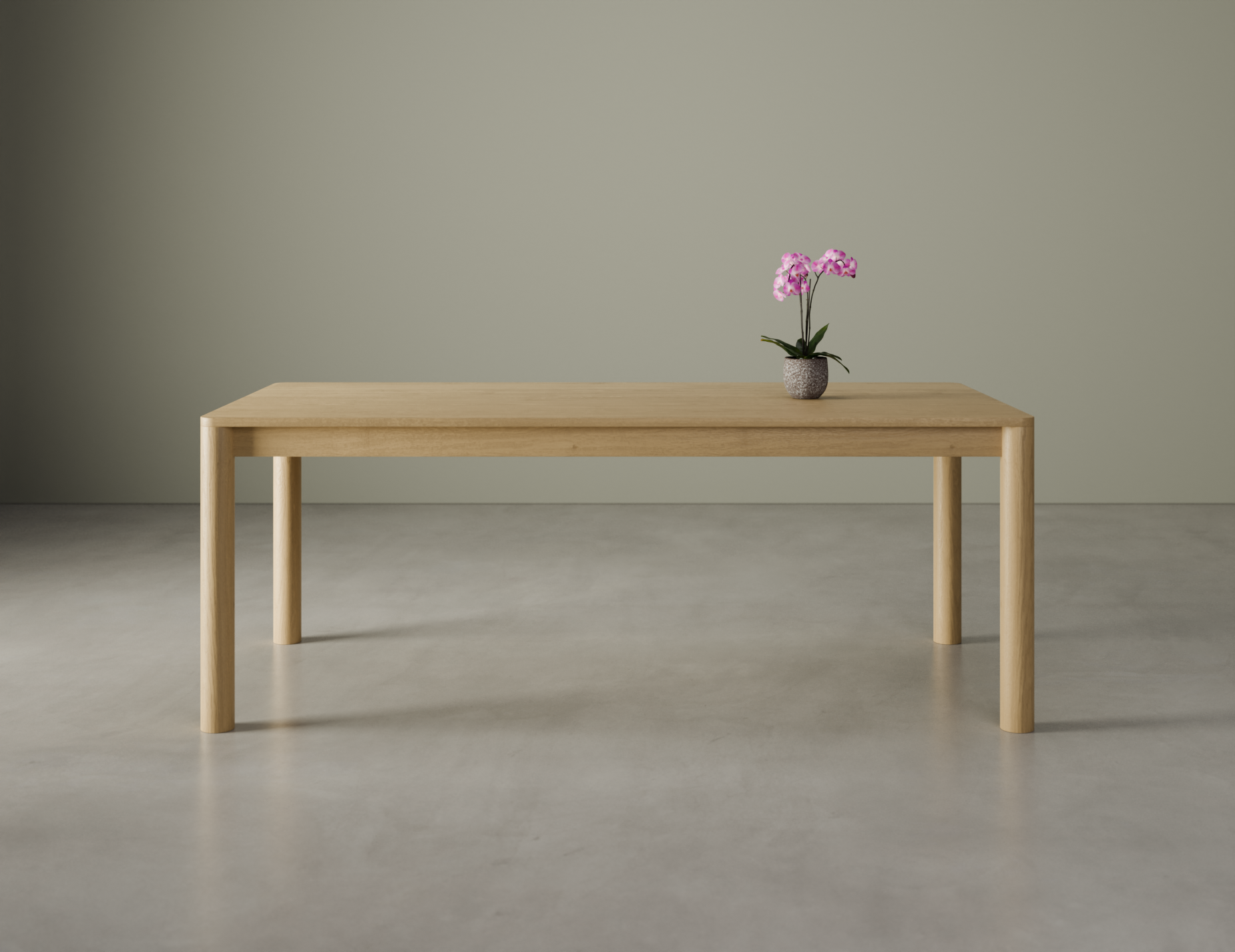 Front view of a medium Nordica wooden dining table in natural oak finish with a flower in a vase on a polished concrete floor.