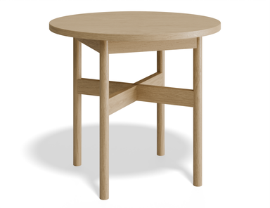 Slightly angled front view of round side table in natural wood finish.