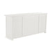 Slightly angled rear view of a white wooden buffet with 4 doors and 4 drawers with antique brass hardware.