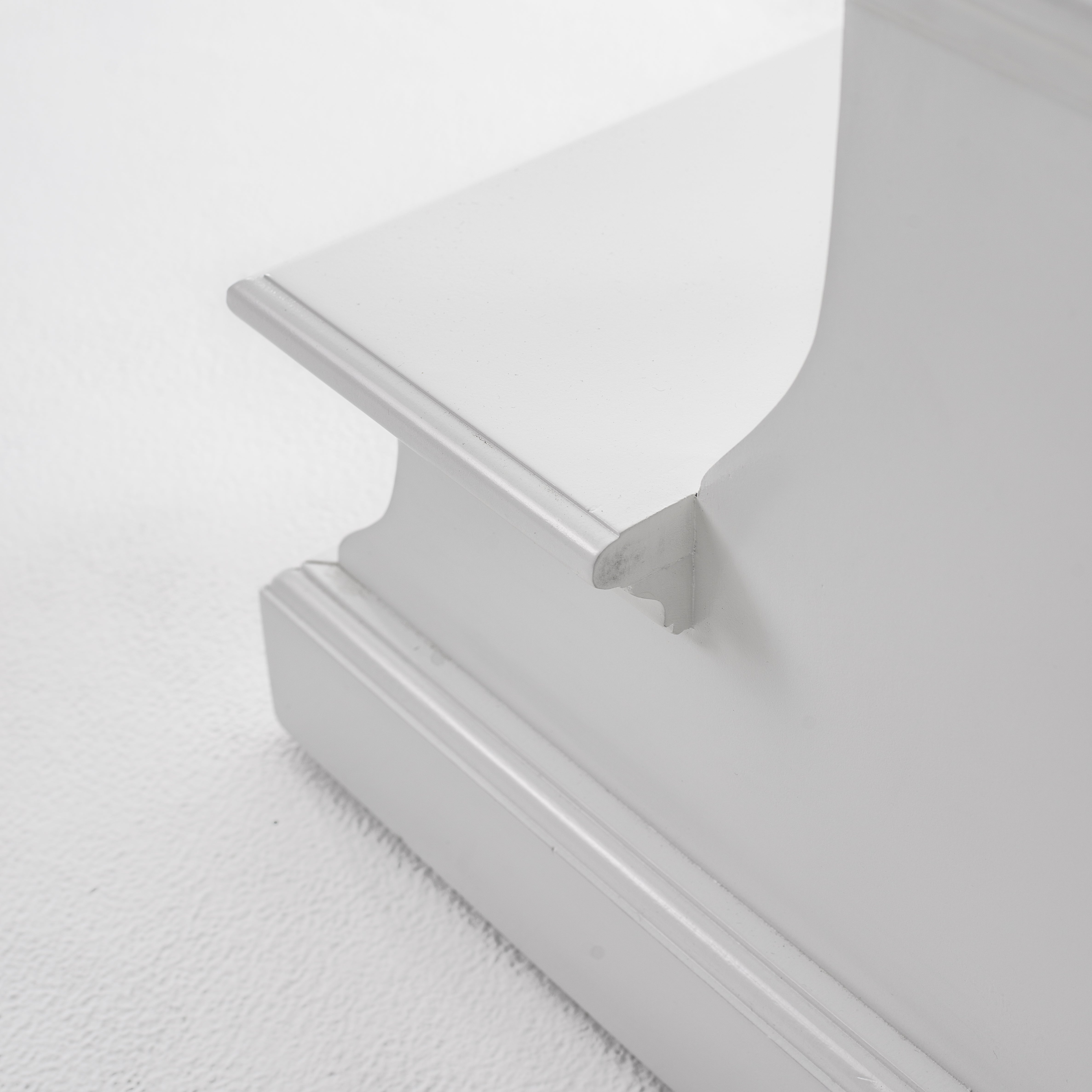 Close-up view of the bottom corner of a white timber bed step.