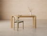 Front lifestyle view of Pier Dining Table - Solid Oak - 160 cm x 90 cm styled in a minimalist dining space with oak chairs and neutral wall backdrop.