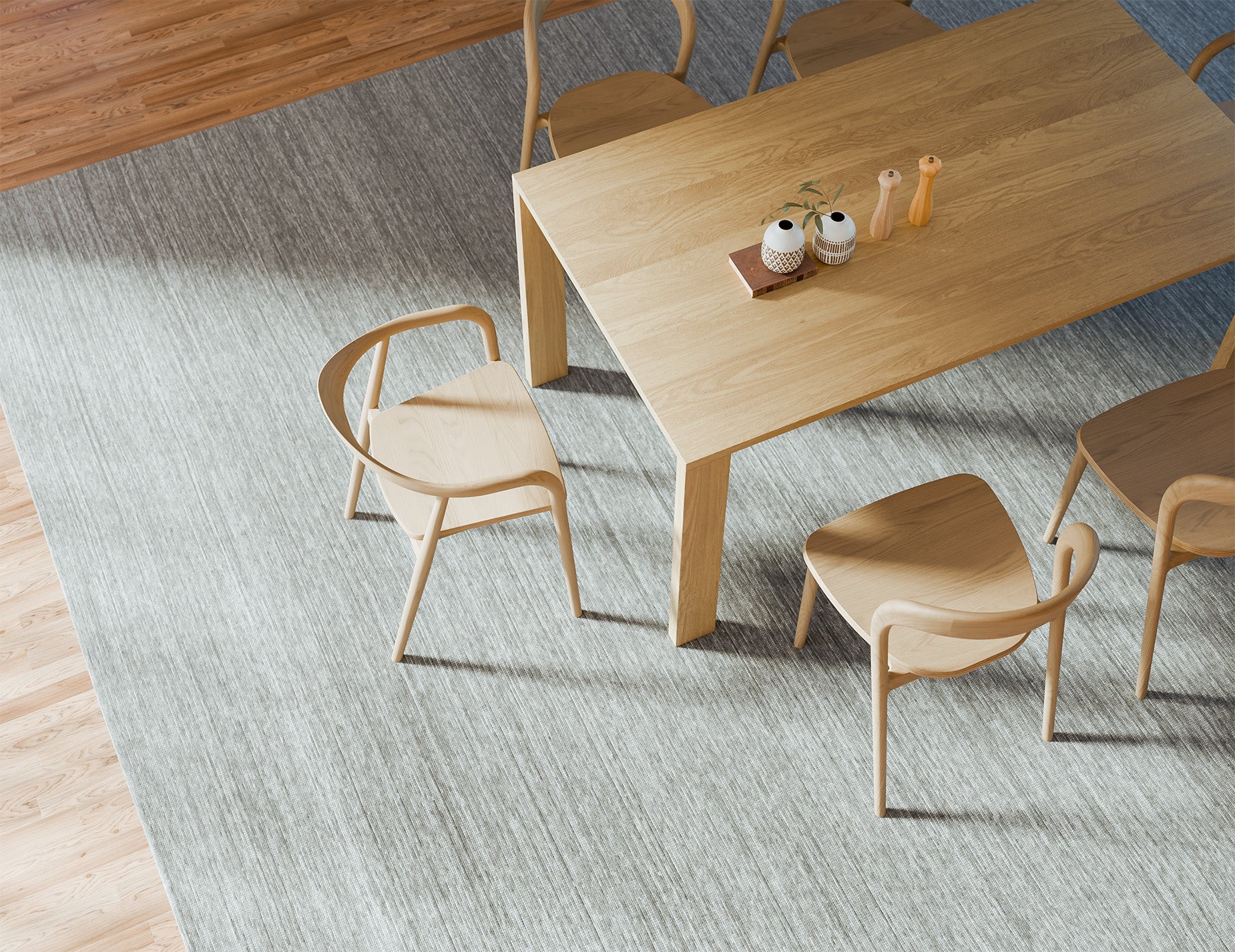 Overhead angled view of Pier Dining Table - Solid Oak - 160 cm x 90 cm styled with ceramic vases and dining chairs on textured rug.