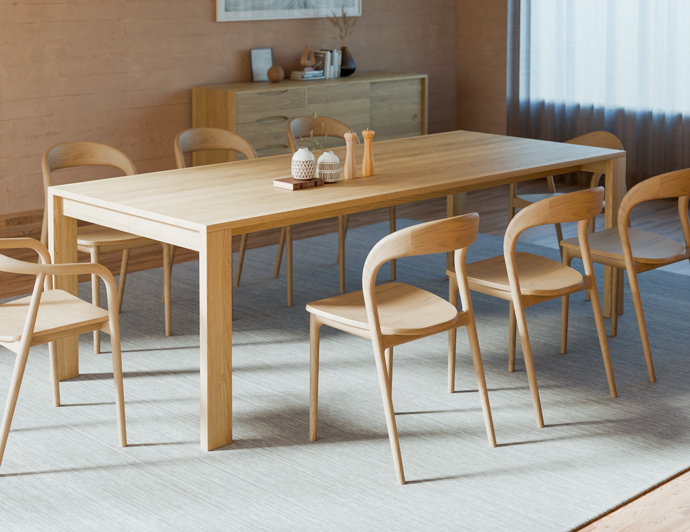 Pier Dining Table – Solid Oak – 240 cm x 100 cm paired with curved wooden dining chairs on grey rug in modern dining space.