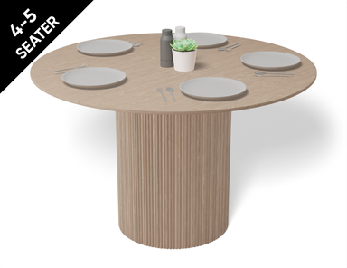 4 to 5 seater round dining table in natural American ash finish displaying plates and cutlery.