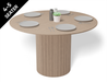 4 to 5 seater round dining table in natural American ash finish displaying plates and cutlery.