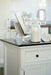 Close-up of the Provence Accent Classic Buffet styled with a recipe book, storage jar and dark timber top in a light kitchen.