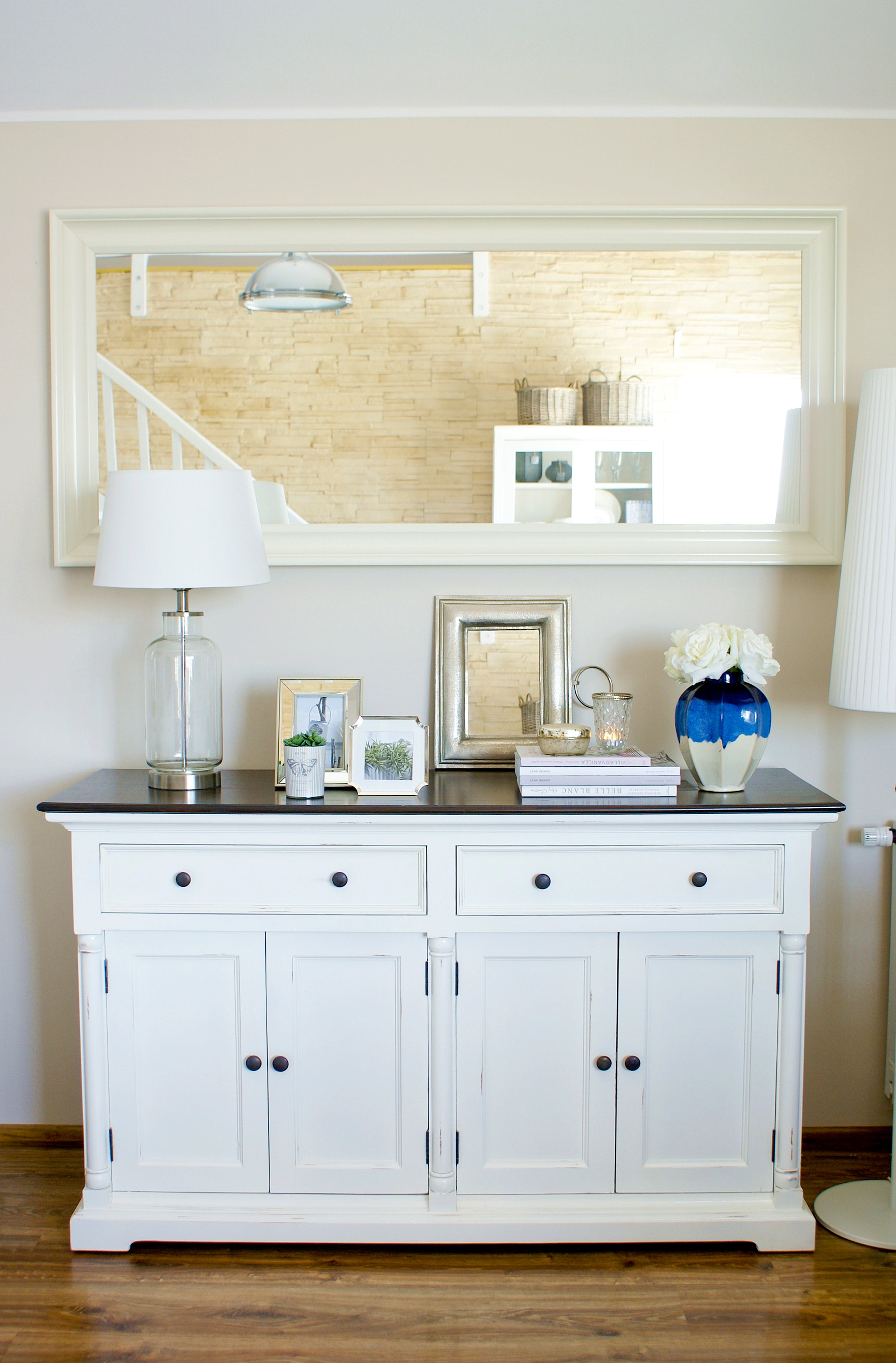 Front view of the Provence Accent Classic Buffet styled beneath a large mirror, featuring a dark timber top, white painted base, drawers and cupboard doors.