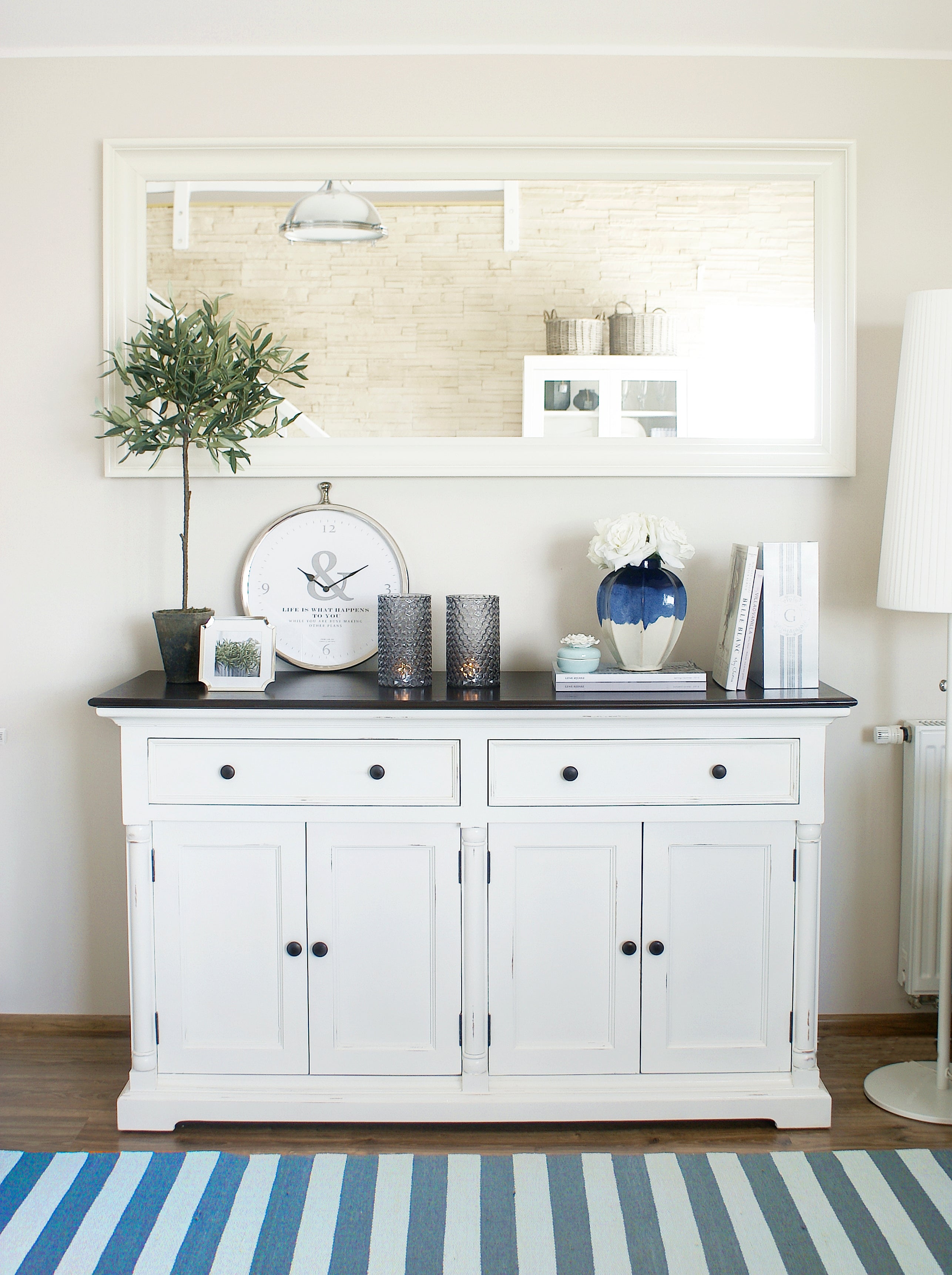 Front view of the Provence Accent Classic Buffet styled beneath a large mirror with decorative vases, candles and books.