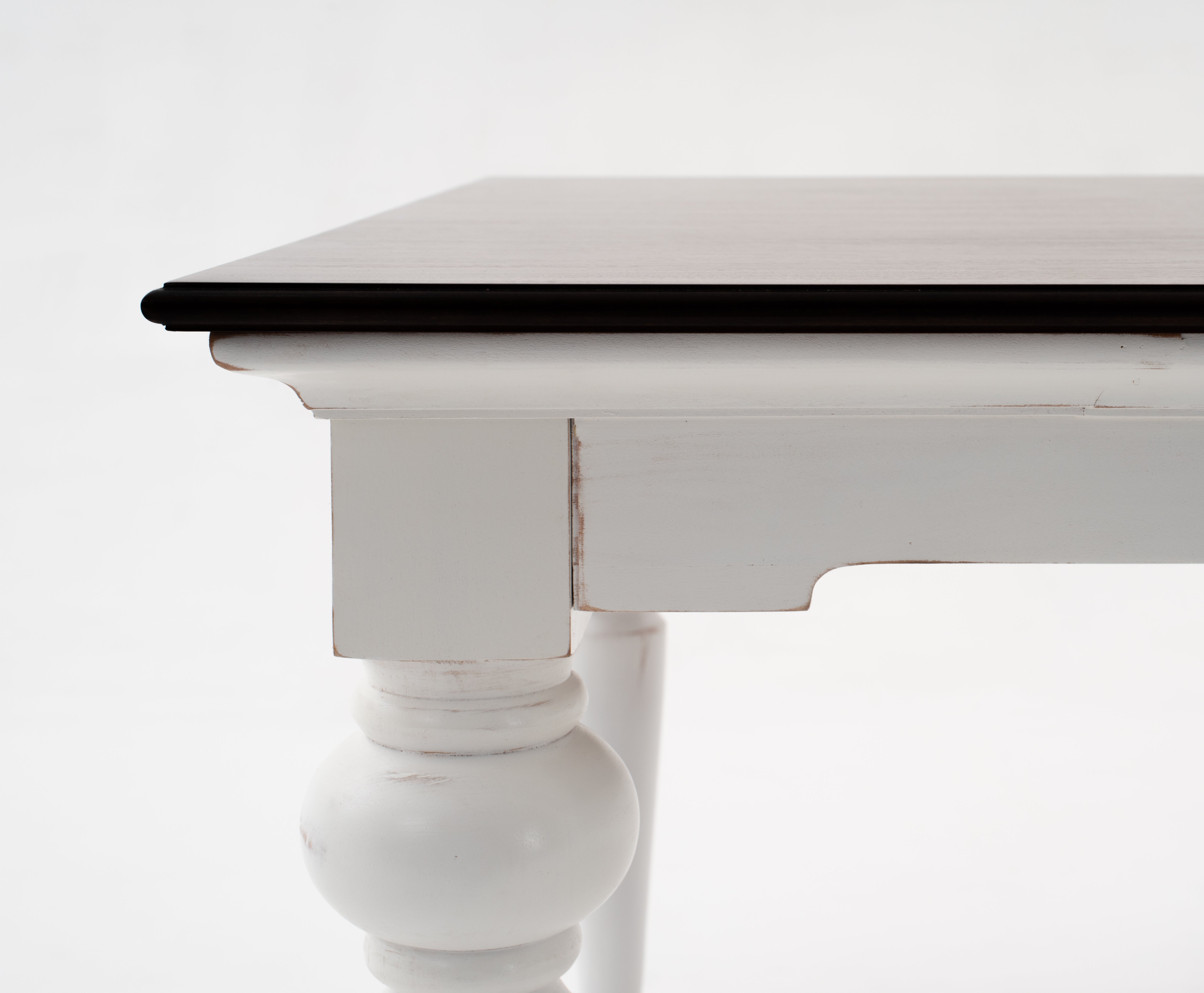 Side detail of the Provence Accent Dining Table with dark timber top, white painted apron and turned leg.