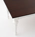 Close-up angled view of the Provence Accent Dining Table showing the dark timber tabletop, shaped edge and white painted base.