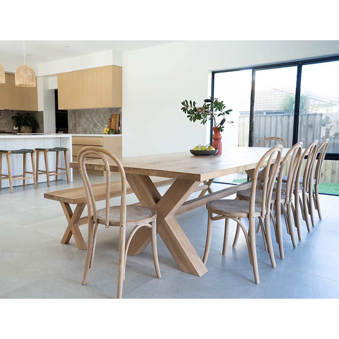 Replica Bentwood Chair in weathered oak styled around a large timber dining table in a bright coastal dining room.
