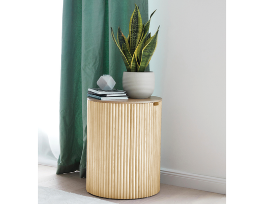 Round side table with ridges in natural ash colour with internal storage displaying a potted plant and books.